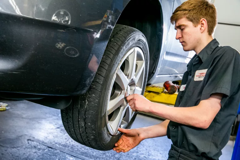A man changing a tire at an auto repair shop