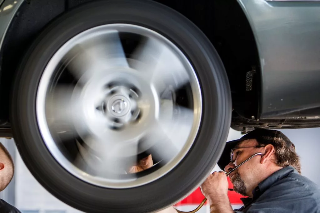 Ken's automotive and transmissions mechanic working on tire