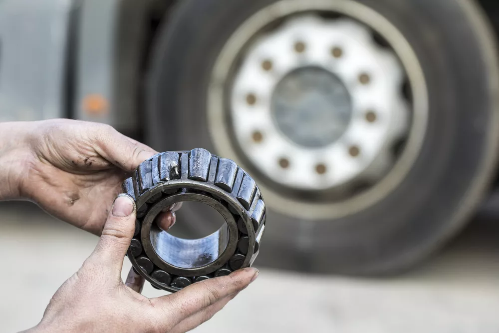 What are the Symptoms of Bad Wheel Bearings? 1 Mechanic,Holding,A,Bearing,Of,The,Hub,Of,The,Truck