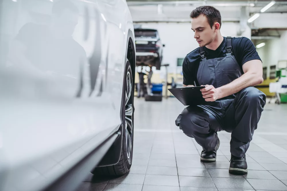 Ken's automotive and transmissions mechanic inspecting tire