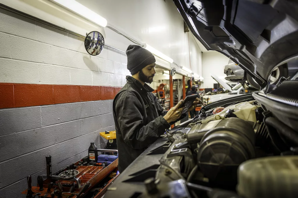 Ken's automotive and transmissions mechanic repairing under hood computer