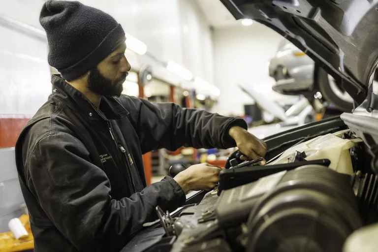 Ken's automotive and transmissions mechanic repairing under hood