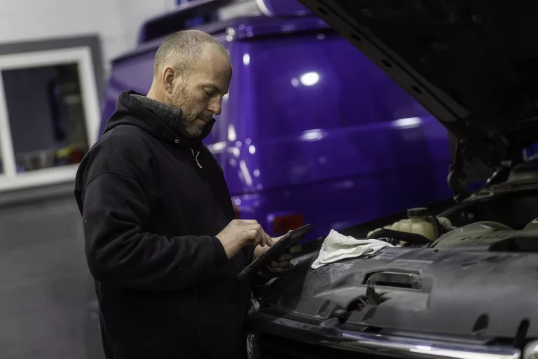 Ken's automotive and transmissions mechanic repairing under hood computer