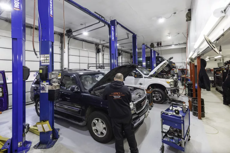 Ken's automotive and transmissions shop floor multiple lift bays truck open hood mechanic