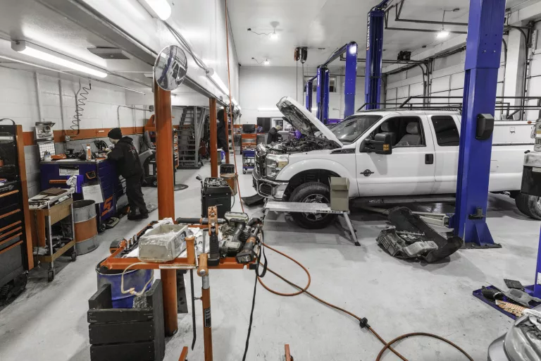 Ken's automotive and transmissions shop floor multiple lift bays truck open hood