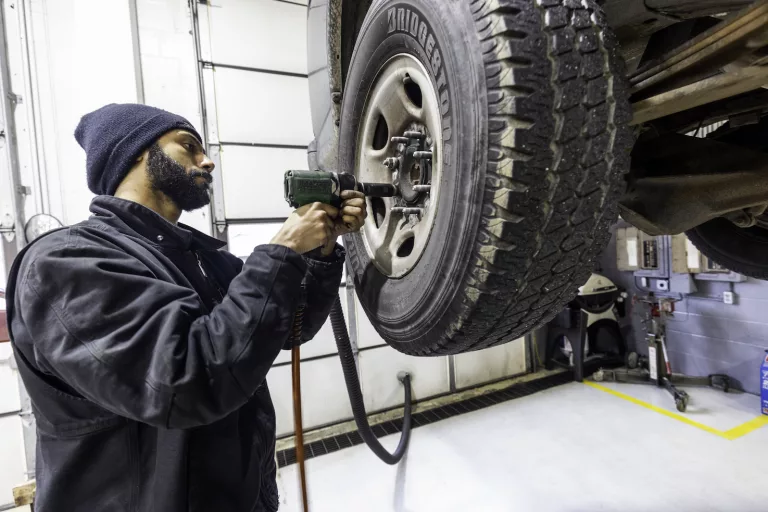 Ken's automotive and transmissions mechanic replacing tire