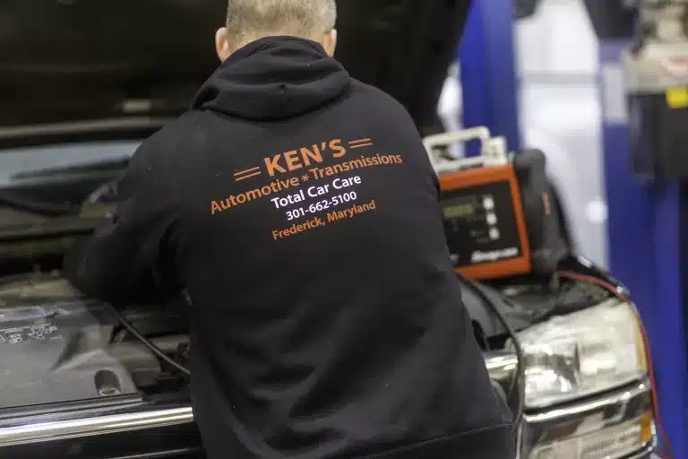 Ken's automotive and transmissions employee working under hood