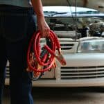 Man Connecting Battery Cable Copper Wire For Repairing Jumpers And Electrical Maintenance Of Engines Car problems that won't start.