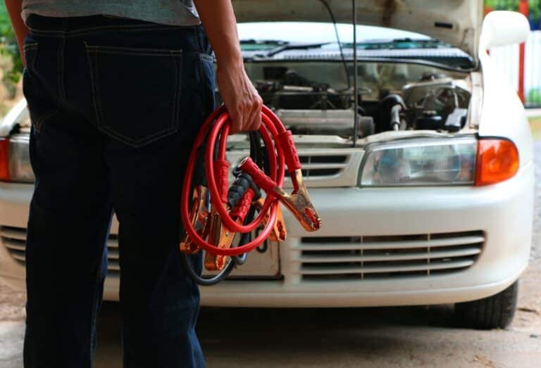 Man Connecting Battery Cable Copper Wire For Repairing Jumpers And Electrical Maintenance Of Engines Car problems that won't start.