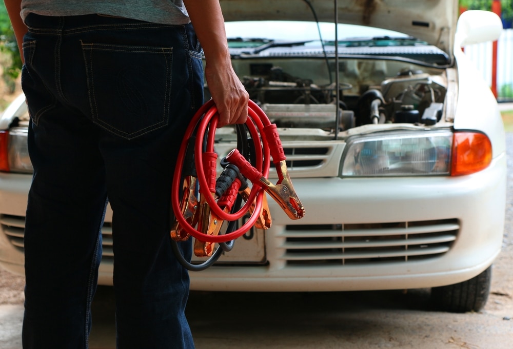 Why Your Battery Keeps Dying—and What It Could Really Mean 1 Man Connecting Battery Cable Copper Wire For Repairing Jumpers And Electrical Maintenance Of Engines Car problems that won't start.