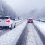 SUV car passing on a german highway with snow slush and snow fall, winter scenery