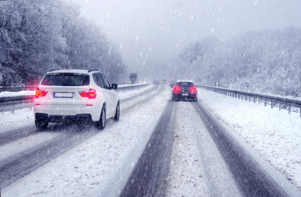 Is Your Vehicle Ready for Cold Weather? 5 Essentials to Check 1 SUV car passing on a german highway with snow slush and snow fall, winter scenery